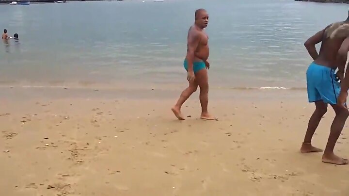 Mestre maludo de sunga treinando na praia